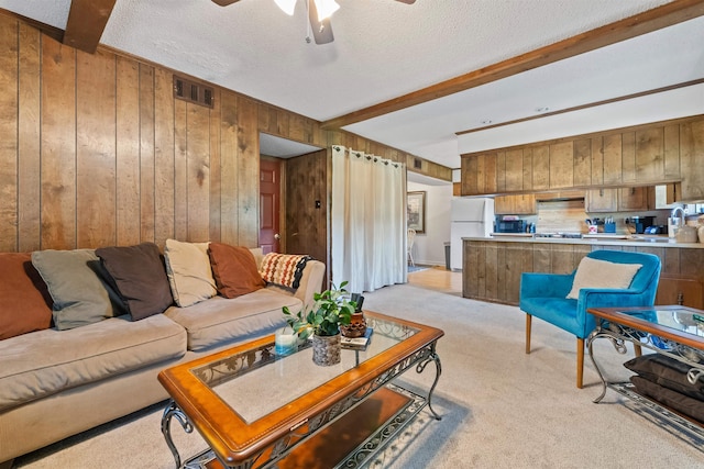 111 Pamela Ln, Sherwood, AR 72120 - living area with wooden walls, visible vents, a ceiling fan, light carpet, and beam ceiling