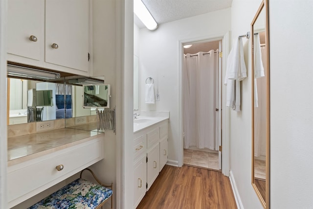 111 Pamela Ln, Sherwood, AR 72120 - full bathroom with wood finished floors, vanity, and a textured ceiling