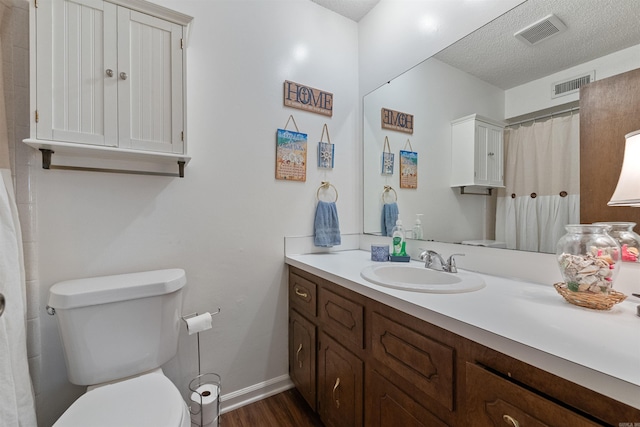 111 Pamela Ln, Sherwood, AR 72120 - full bath featuring a textured ceiling, toilet, visible vents, wood finished floors, and vanity