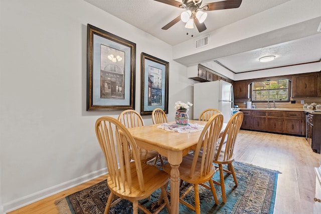 111 Pamela Ln, Sherwood, AR 72120 - dining space with a textured ceiling, light wood-type flooring, baseboards, visible vents, and a ceiling fan