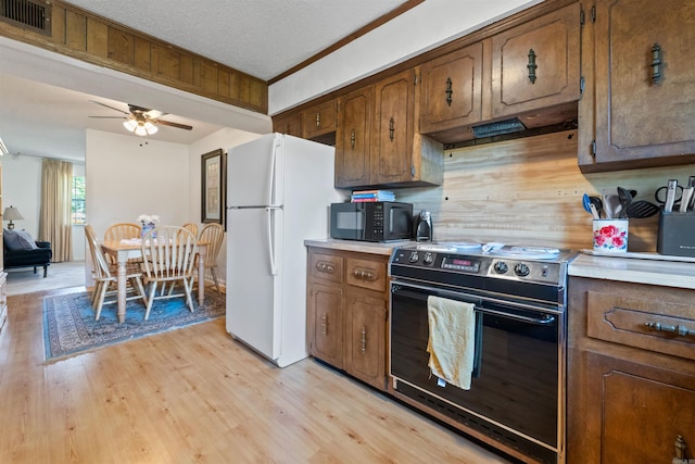 111 Pamela Ln, Sherwood, AR 72120 - kitchen featuring black microwave, range with electric stovetop, under cabinet range hood, visible vents, and freestanding refrigerator