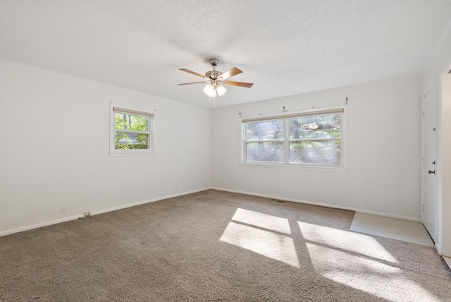 unfurnished room featuring a ceiling fan, baseboards, a wealth of natural light, and light colored carpet