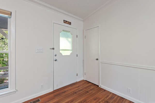 entryway featuring a textured ceiling, ornamental molding, and dark wood finished floors