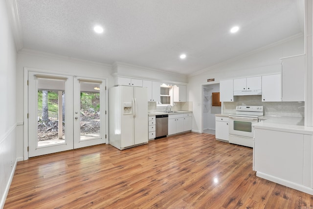 kitchen with decorative backsplash, light countertops, white appliances, and ornamental molding