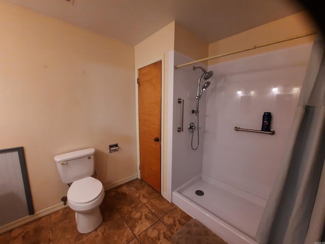 bathroom featuring walk in shower, tile patterned flooring, and toilet