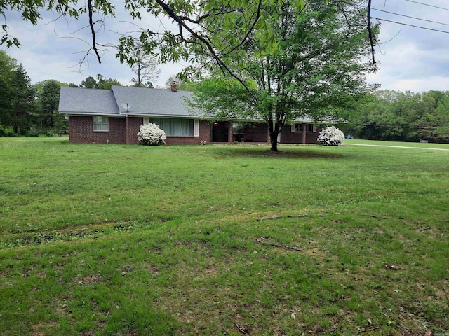 view of front of property featuring a chimney and a front yard