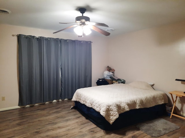 bedroom featuring wood finished floors, visible vents, and a ceiling fan