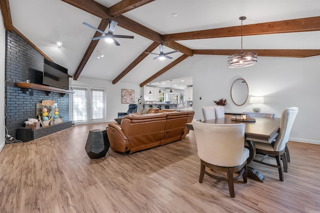 dining space featuring light wood finished floors, vaulted ceiling with beams, a ceiling fan, and baseboards