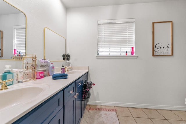 full bathroom featuring baseboards, tile patterned flooring, a sink, and double vanity