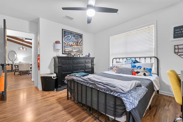 bedroom featuring light wood-type flooring, a ceiling fan, and visible vents