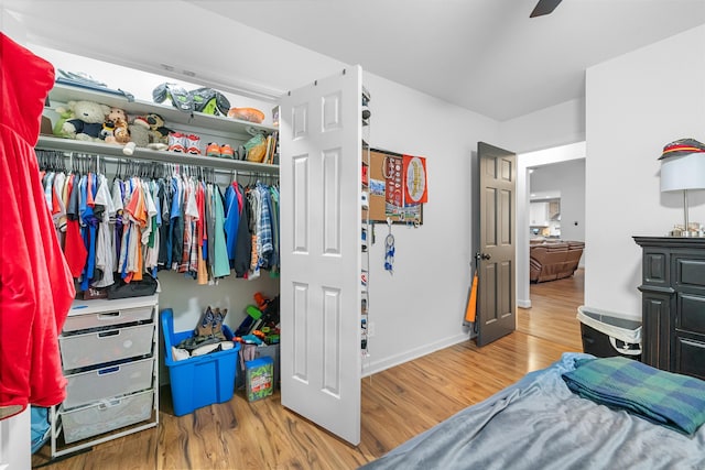 bedroom with wood finished floors, a closet, baseboards, and ceiling fan