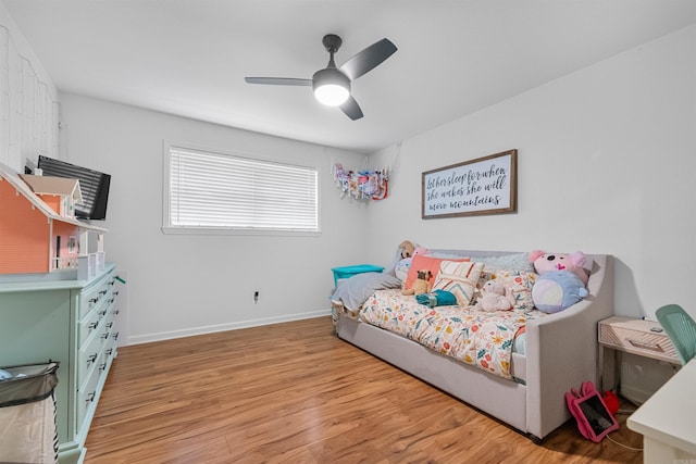 bedroom featuring light wood finished floors, a ceiling fan, and baseboards