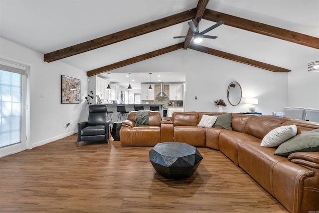 living room with lofted ceiling with beams, baseboards, recessed lighting, light wood-style floors, and a ceiling fan