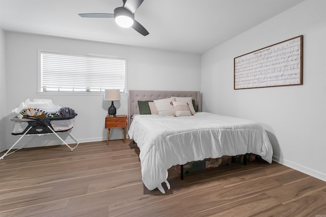 bedroom featuring baseboards, wood finished floors, and ceiling fan