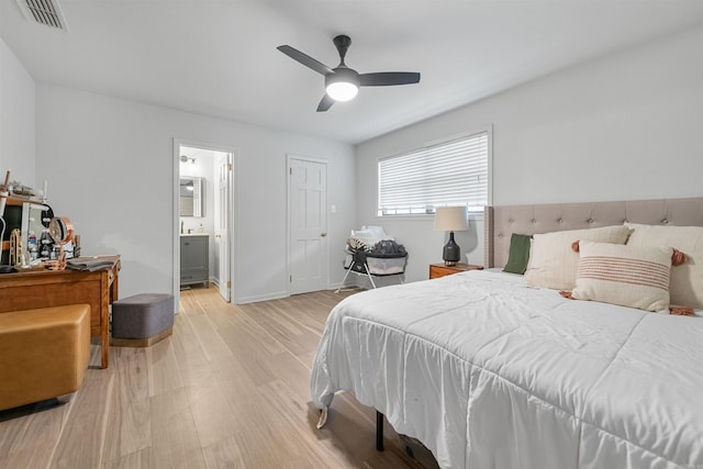 bedroom with ensuite bathroom, ceiling fan, light wood finished floors, baseboards, and visible vents