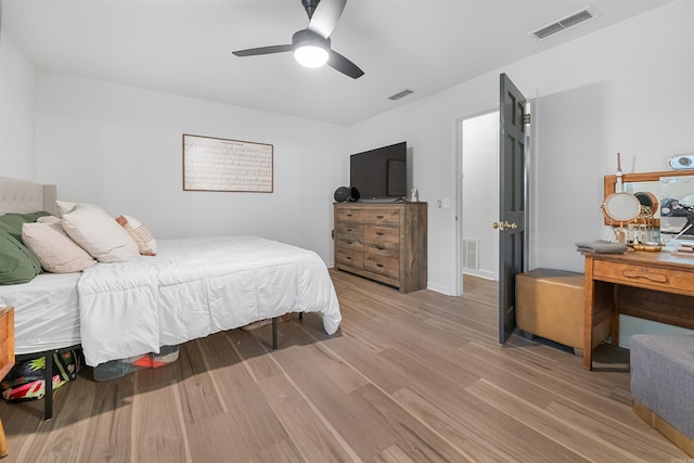 bedroom featuring light wood-style flooring, visible vents, and ceiling fan