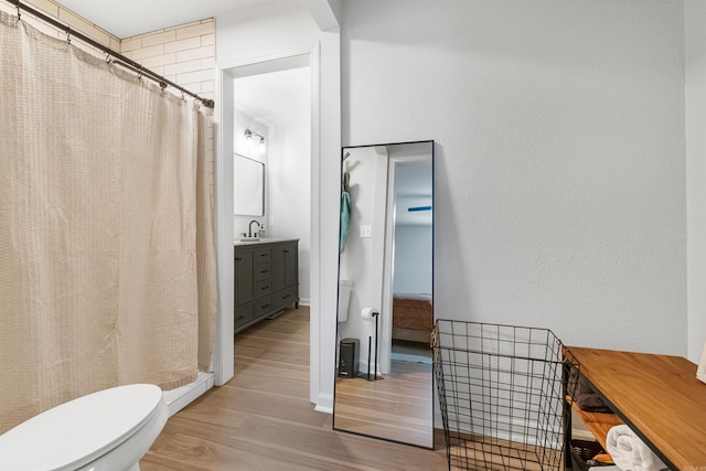 full bathroom featuring wood finished floors, toilet, vanity, and a shower with curtain