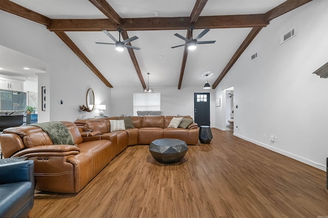living area featuring beamed ceiling, visible vents, and a ceiling fan