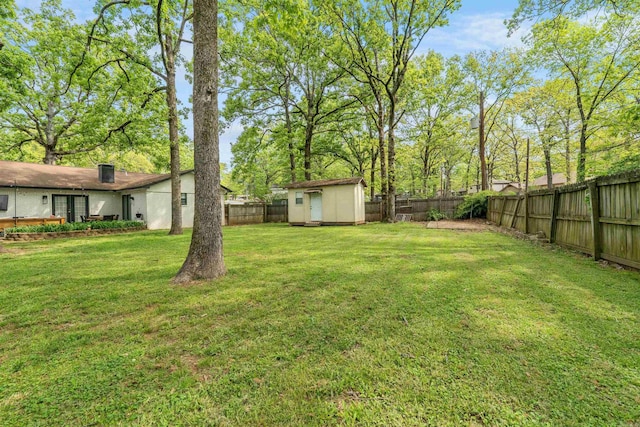 view of yard with a storage shed, an outbuilding, and a fenced backyard