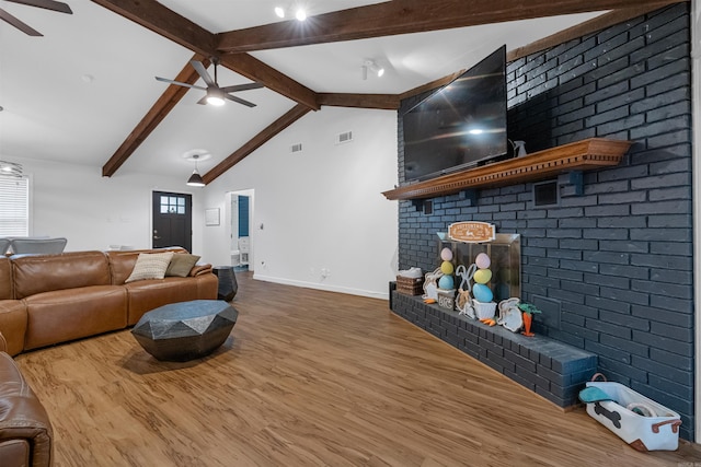 living area featuring wood finished floors, a brick fireplace, a ceiling fan, and baseboards