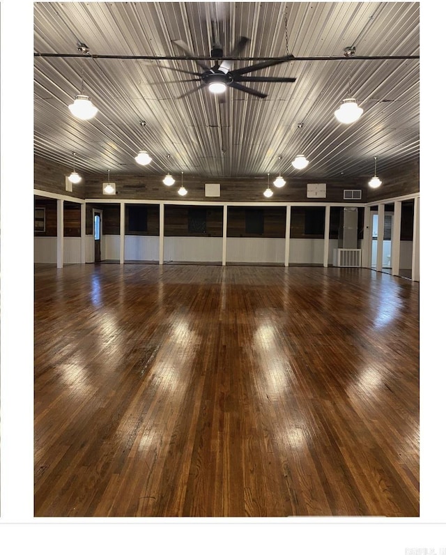 unfurnished room featuring a ceiling fan, hardwood / wood-style floors, and visible vents