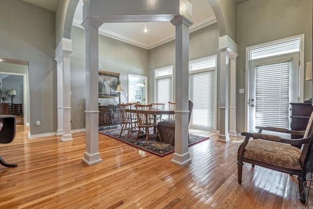 interior space featuring arched walkways, a high ceiling, ornamental molding, and decorative columns