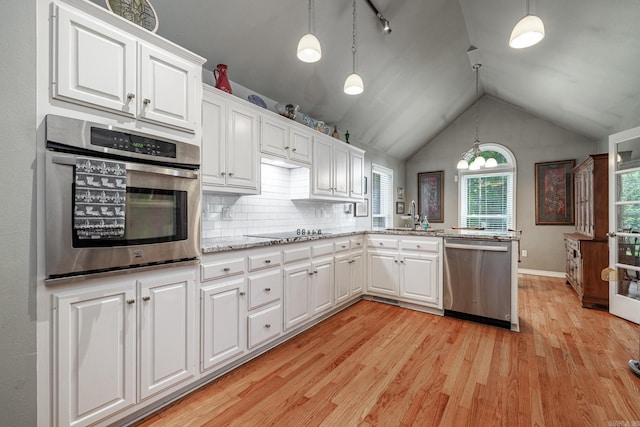 kitchen featuring white cabinets, a peninsula, stainless steel appliances, and a sink