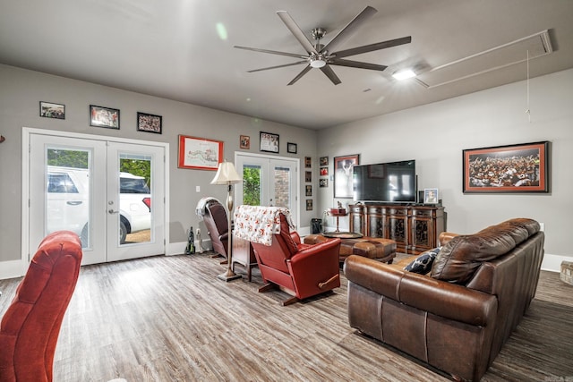 living area with a ceiling fan, wood finished floors, attic access, french doors, and baseboards