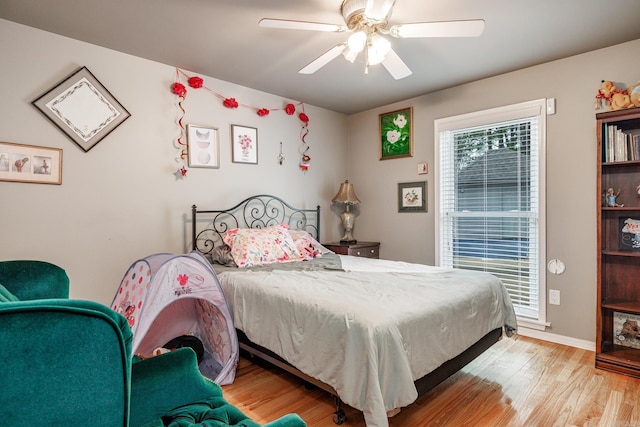bedroom featuring ceiling fan, baseboards, and light wood-type flooring
