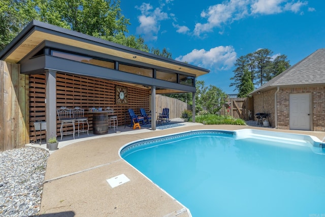 view of pool with outdoor dry bar, a fenced in pool, a patio, and fence