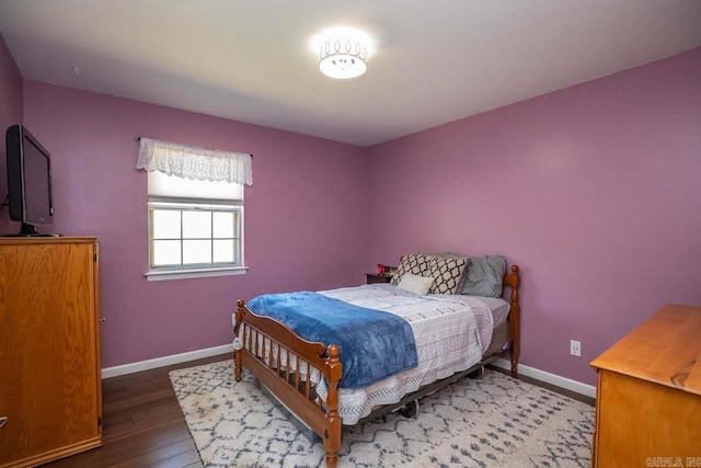 bedroom with wood finished floors and baseboards