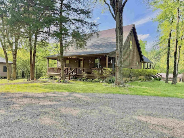 chalet / cabin with roof with shingles and covered porch