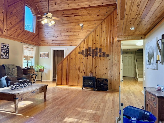 living room with light wood finished floors, a ceiling fan, wooden ceiling, and stairs