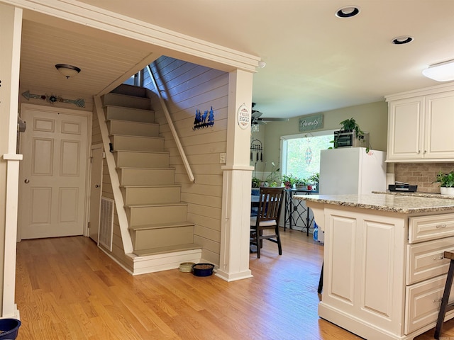 staircase with a ceiling fan, wood finished floors, and recessed lighting