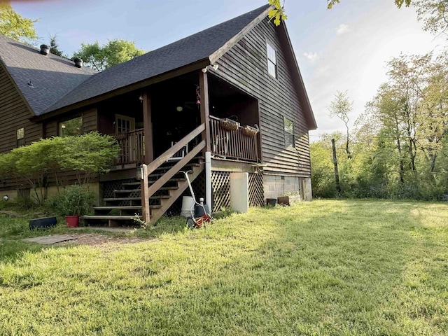 exterior space with a lawn, stairs, and a shingled roof