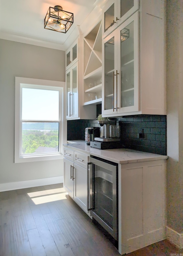 157 Manitou Dr, Maumelle, AR 72113 - bar featuring wine cooler, baseboards, decorative backsplash, crown molding, and dark wood-type flooring