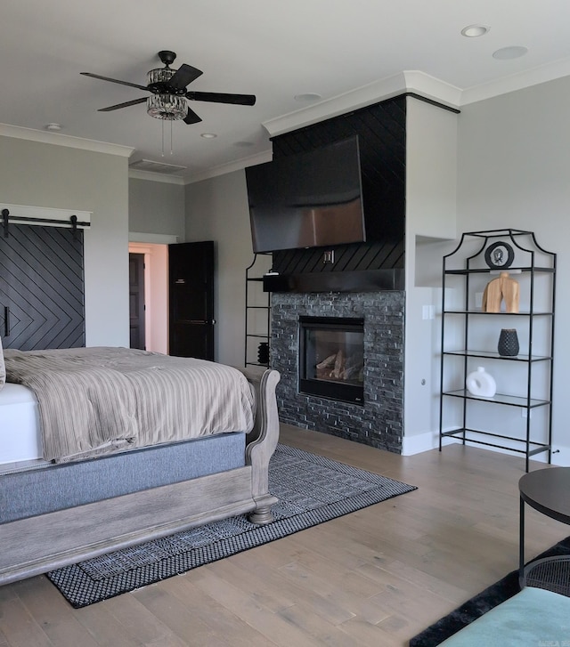 157 Manitou Dr, Maumelle, AR 72113 - bedroom with crown molding, wood finished floors, a glass covered fireplace, ceiling fan, and recessed lighting