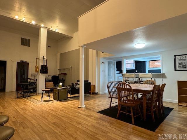 107 N Marr St, Pocahontas, AR 72455 - dining space with baseboards, a towering ceiling, visible vents, ornate columns, and wood finished floors