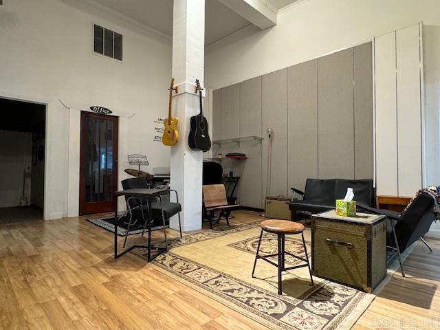 107 N Marr St, Pocahontas, AR 72455 - living area with a high ceiling, crown molding, visible vents, and light wood-style flooring