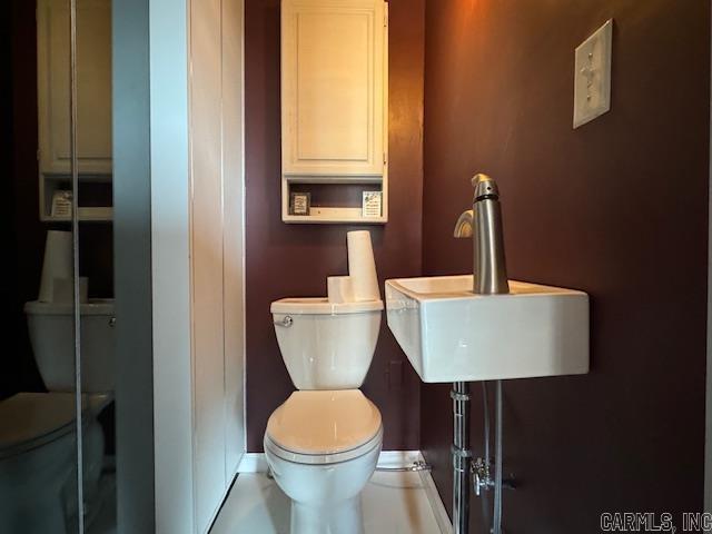 107 N Marr St, Pocahontas, AR 72455 - half bathroom with toilet, baseboards, and a sink