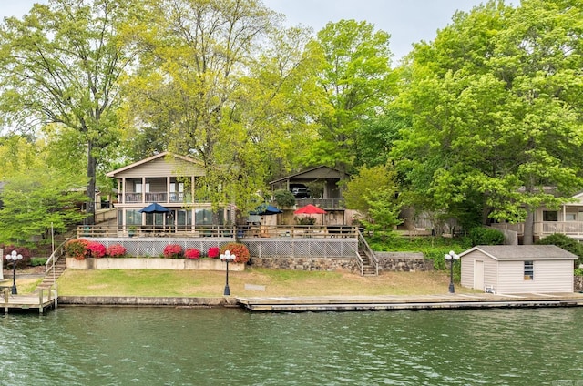 view of dock with a deck with water view, a yard, and stairs