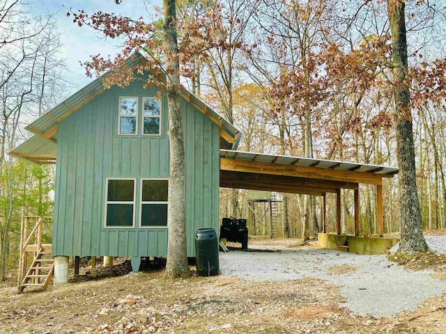 view of outdoor structure featuring driveway and an attached carport