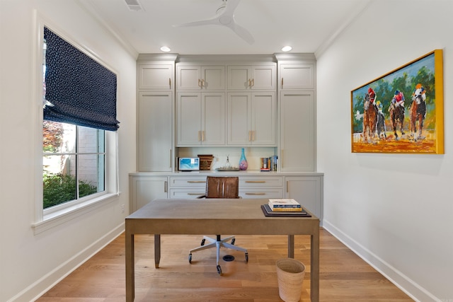 office space with a ceiling fan, baseboards, ornamental molding, and light wood-style floors