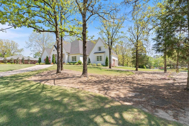 view of property exterior featuring an attached garage, driveway, and a lawn