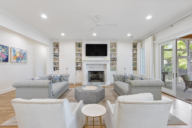 living area featuring recessed lighting, a high end fireplace, a ceiling fan, and light wood finished floors