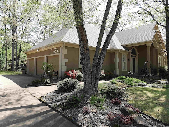 22 Talais Dr, Little Rock, AR 72223 - view of side of home featuring an attached garage, stucco siding, and aphalt driveway