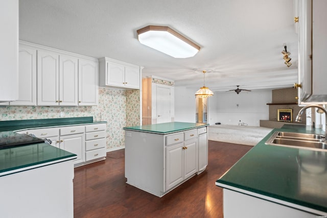 118 Grandview Dr, Hot Springs, AR 71913 - kitchen with a brick fireplace, a ceiling fan, white cabinetry, and a sink