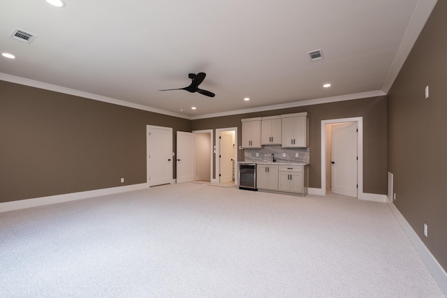 219 Abington Cir, Little Rock, AR 72223 - unfurnished living room with light colored carpet, ornamental molding, recessed lighting, a ceiling fan, and beverage cooler