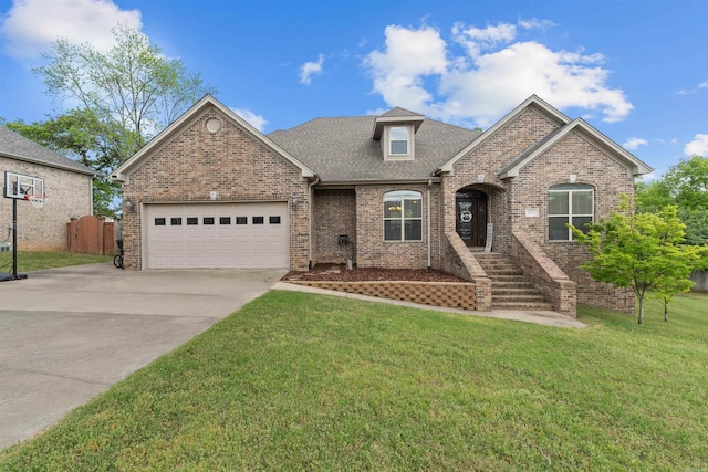 109 Sandstone Cv, Sherwood, AR 72120 - view of front facade with a front lawn, driveway, brick siding, an attached garage, and a shingled roof
