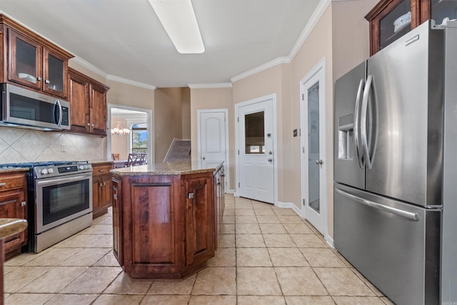 109 Sandstone Cv, Sherwood, AR 72120 - kitchen with a center island, a chandelier, decorative backsplash, appliances with stainless steel finishes, and ornamental molding